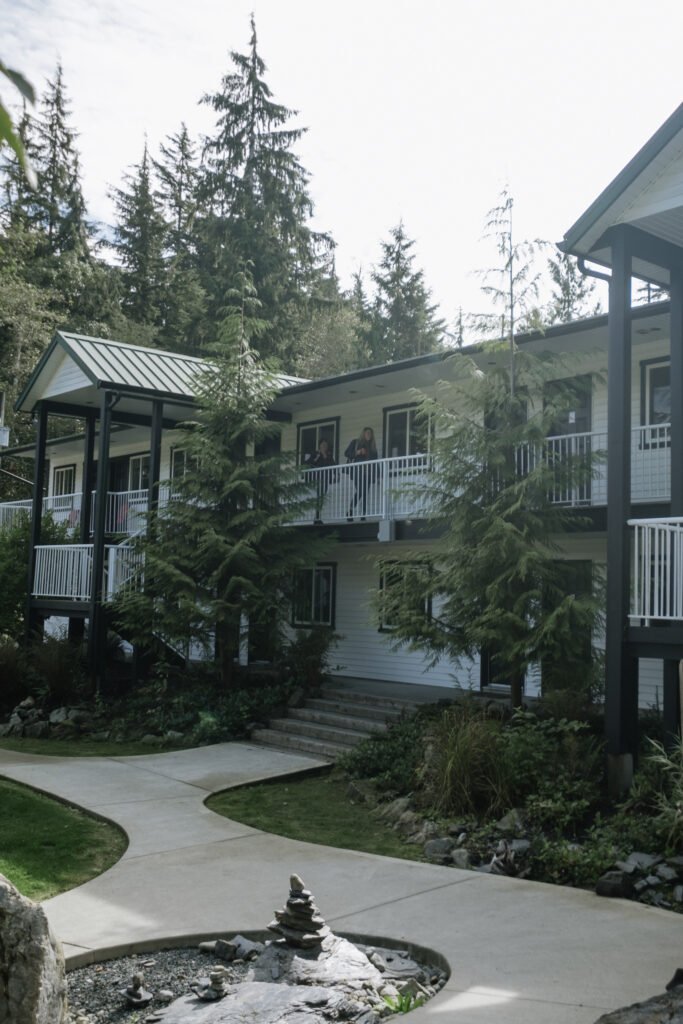 Port Renfrew's West Coast Trail Lodge surrounded by trees and sunshine