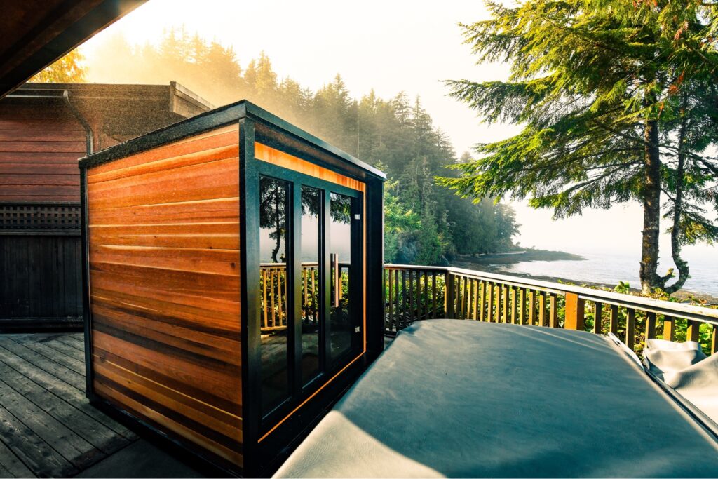 A small wooden cabin on a deck overlooking a body of water